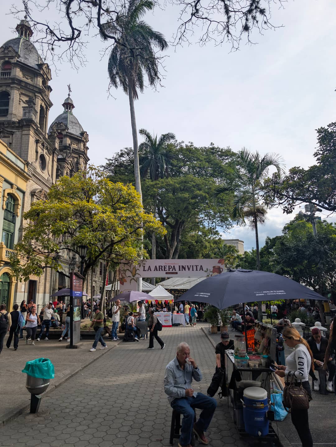 The square: church, palms, a band and stalls.