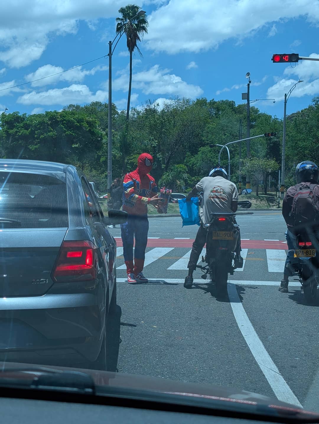 Vedle motorkář, za ním stánek s vodou.