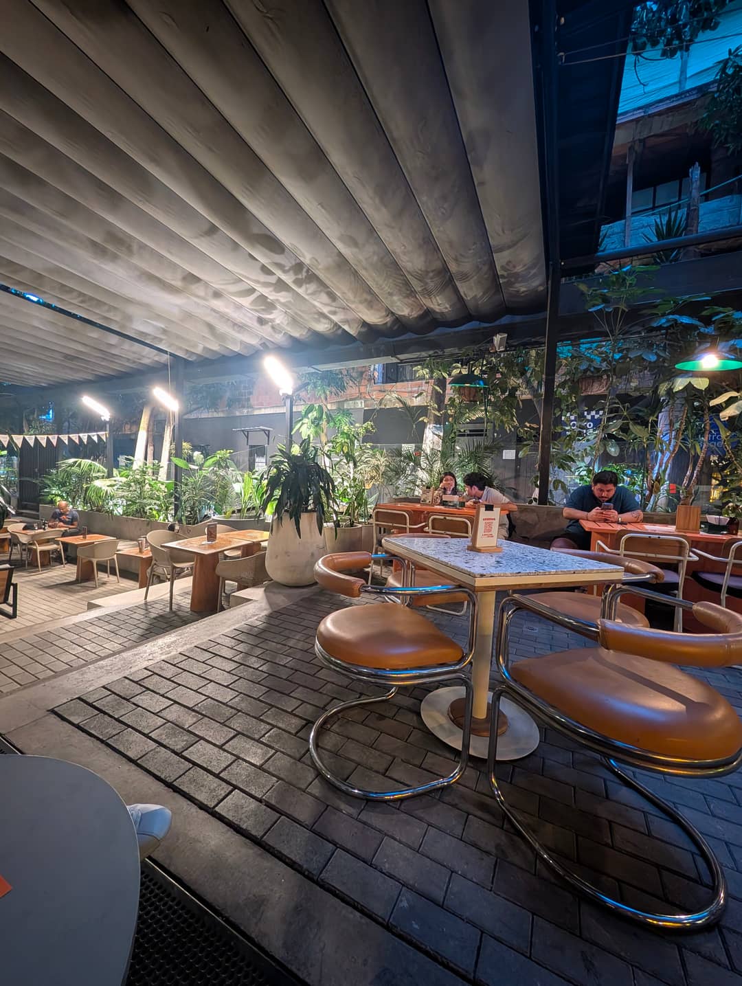 Tables under a concrete ceiling, right next to the pavement.