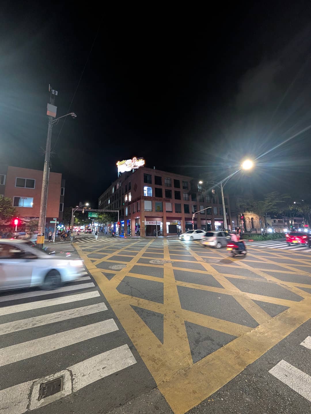 A junction with yellow hatching at night.