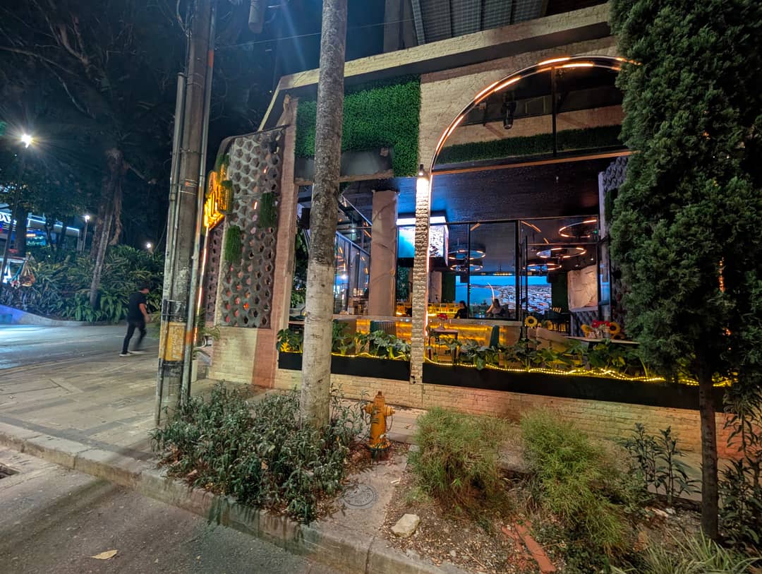 Greenery, neon, and a wall made of plants.