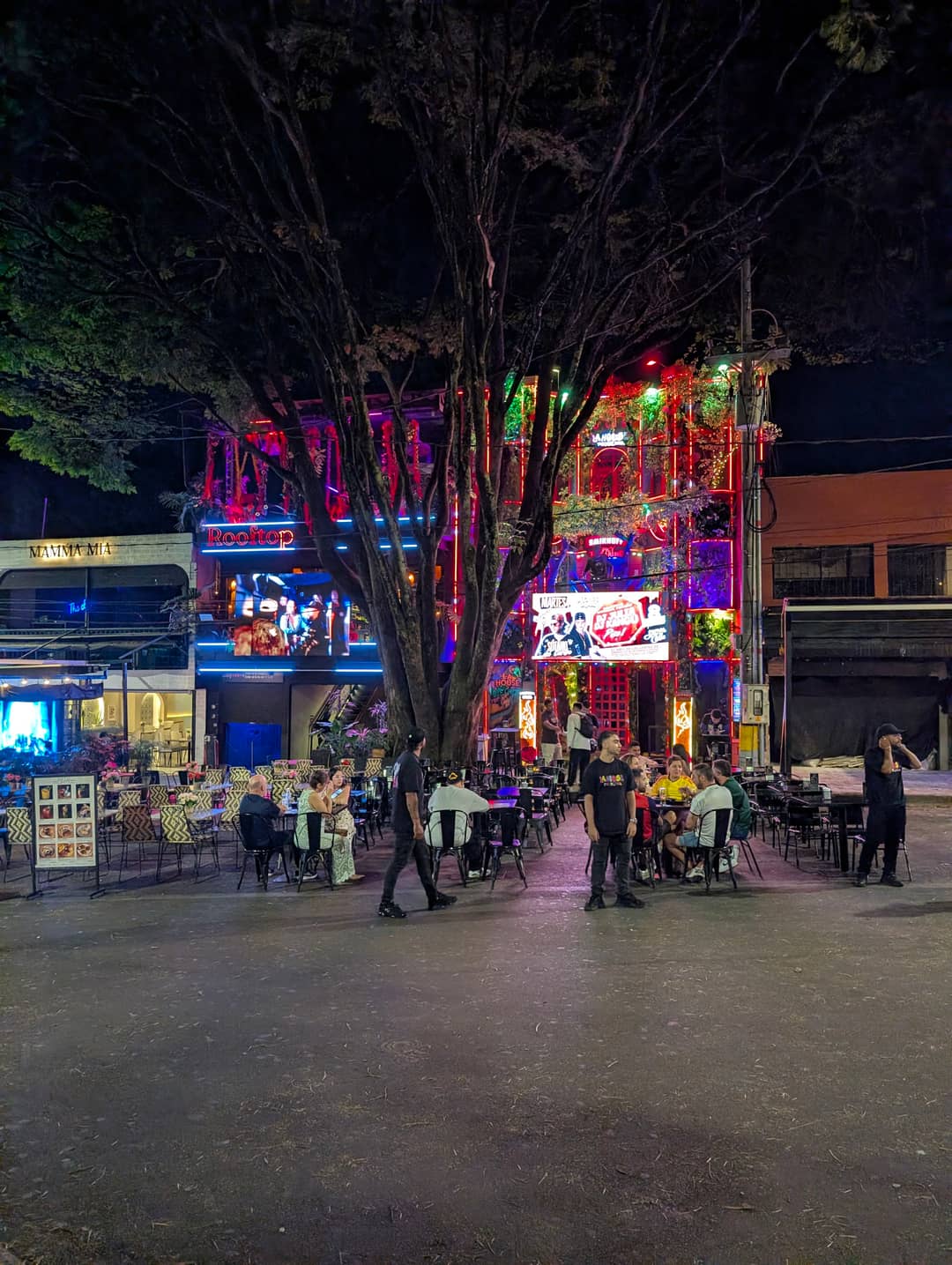 Parque Lleras. Neon, rooftops and tables out onto the pavement.