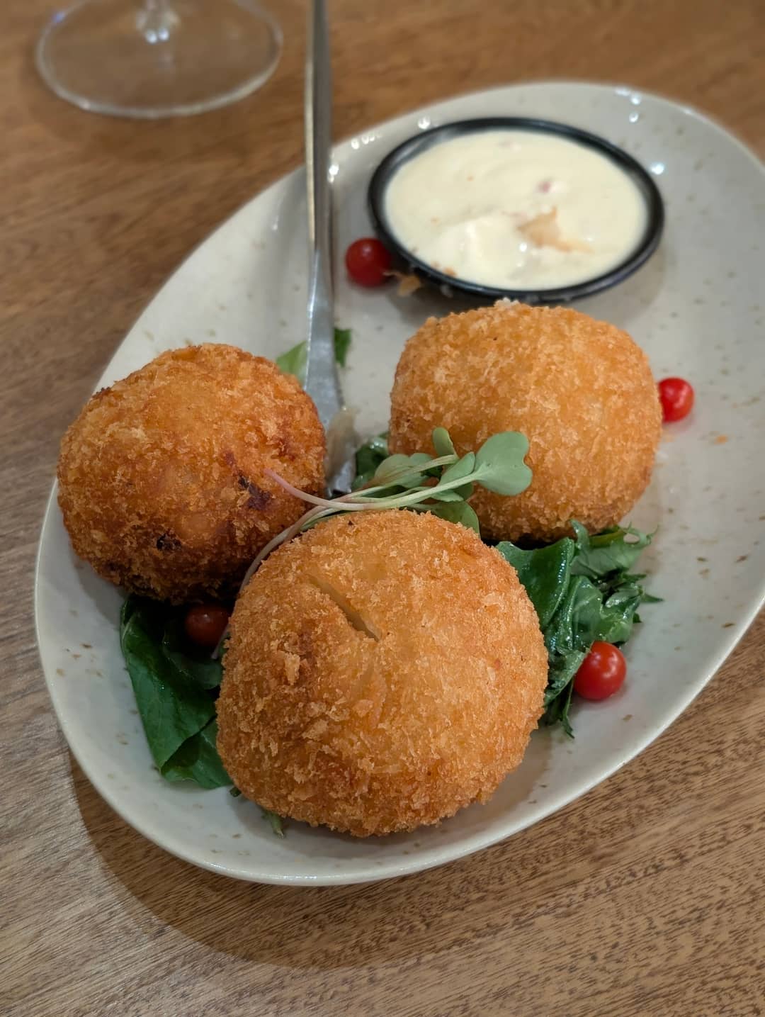 Tři krokety z juky s masem uvnitř, k tomu bílý dip. Provenza, El Poblado.