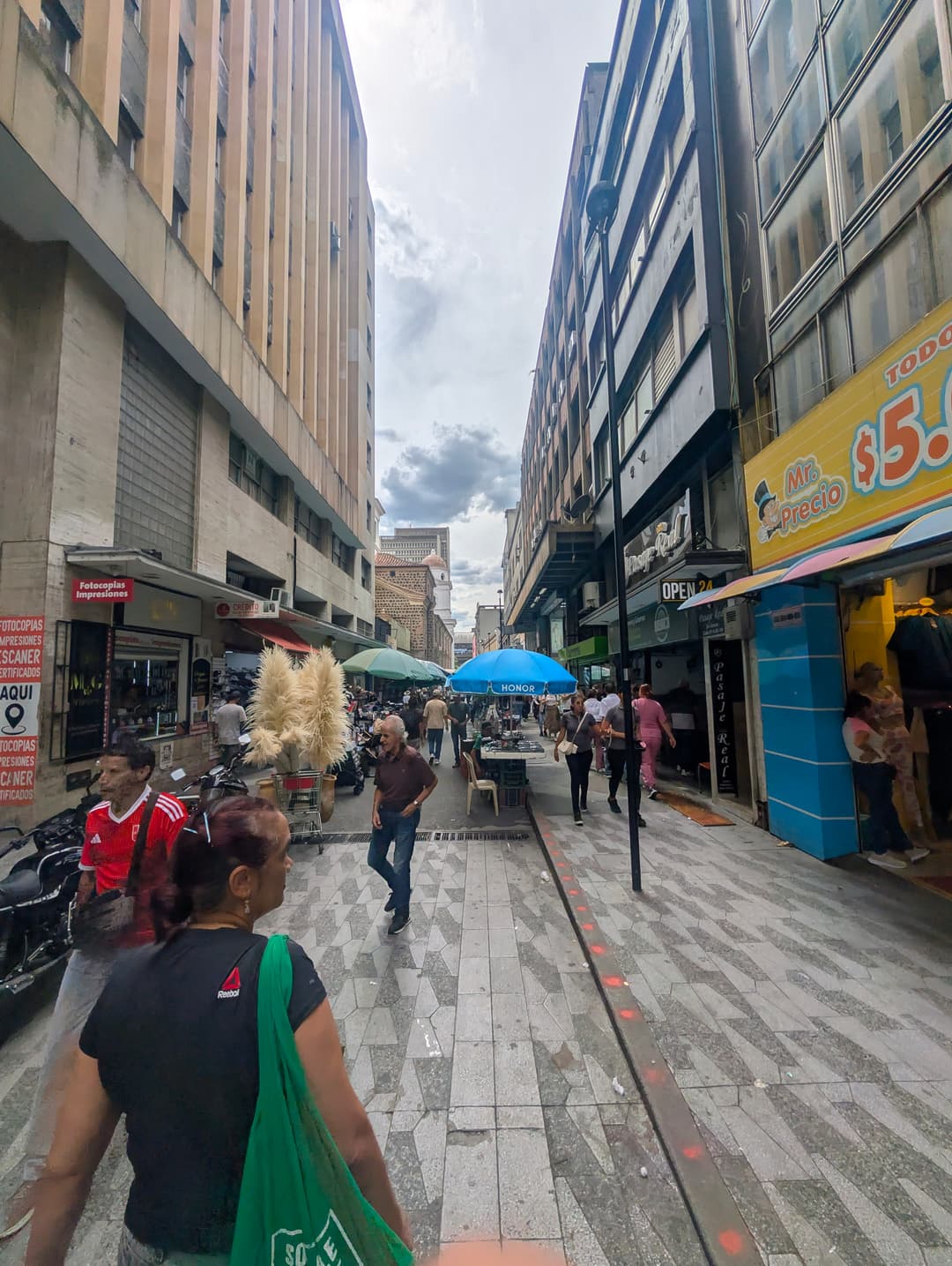 The pavement in front of the shops on a Saturday afternoon.