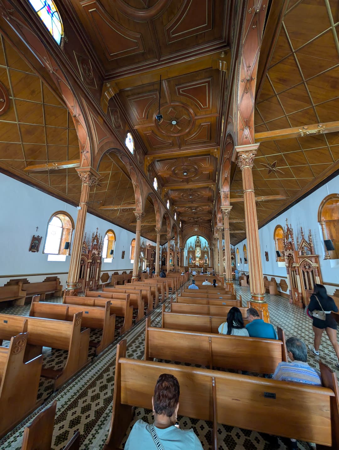 Inside: a wooden ceiling and rows of pews.