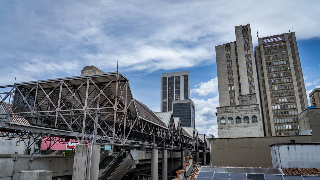 The steel structure of a metro station and the towers around it.